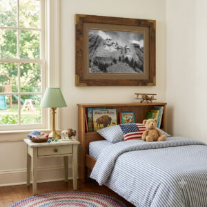Mount Rushmore Wall Art showing black and white carved presidential faces on the rocky mountain monument in a frame in a kid's room.
