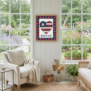 Photo showing a framed print of an American flag graphic inside of a heart with the word BRAVE below it.