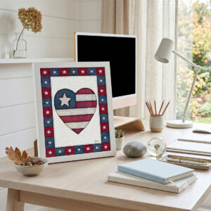 Photo showing a framed print of an American flag graphic inside of a heart.