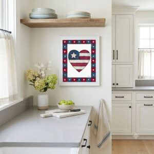 Photo showing a framed print of an American flag graphic inside of a heart.