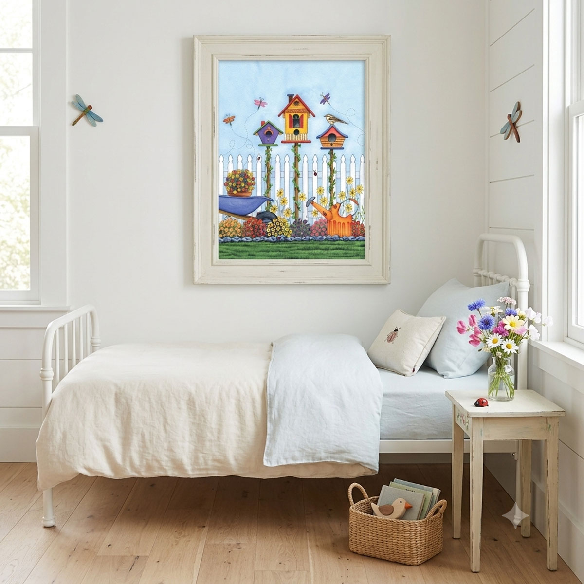 Watercolor art featuring three colorful birdhouses, flowers, dragonflies, and a picket fence - framed on a cottage bedroom wall